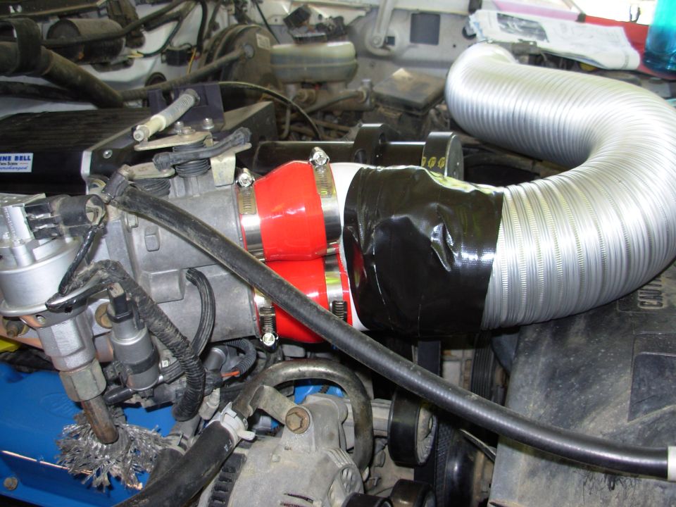 Custom intake tubing with red coupler and black tape on engine