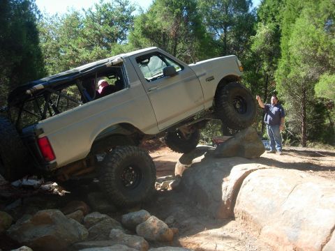 1995 Ford Bronco - A modified Ford Bronco navigates a challenging rocky terrain during an off-road excursion.