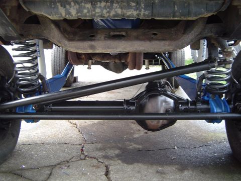 1978 Ford Bronco - The underside of a vehicle reveals its modified suspension and drivetrain components.
