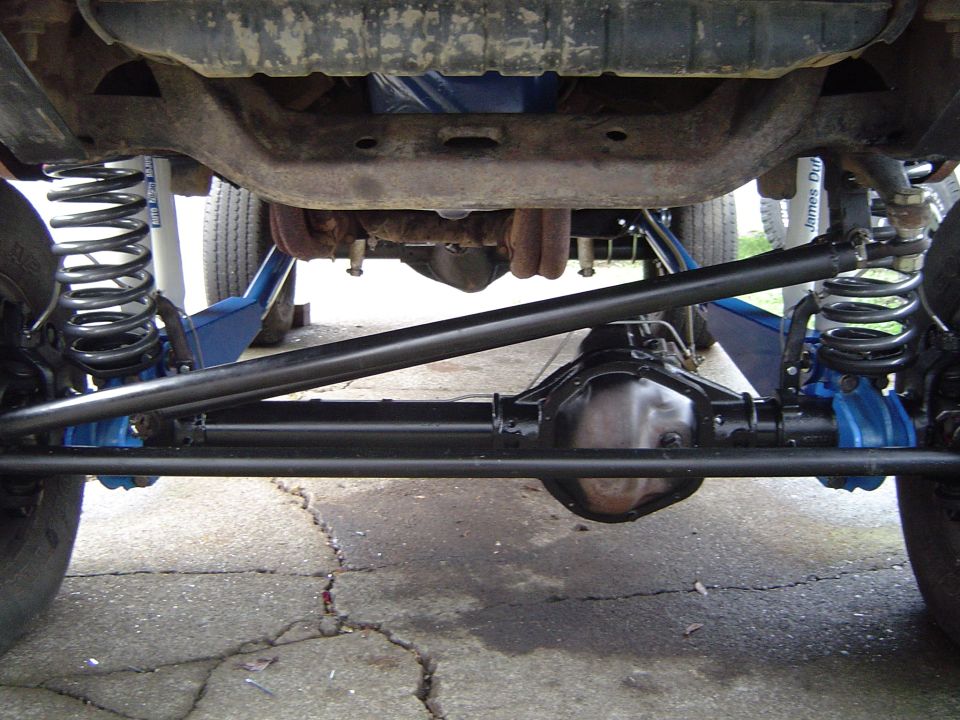 Undercarriage of a lifted vehicle showing suspension components and differential