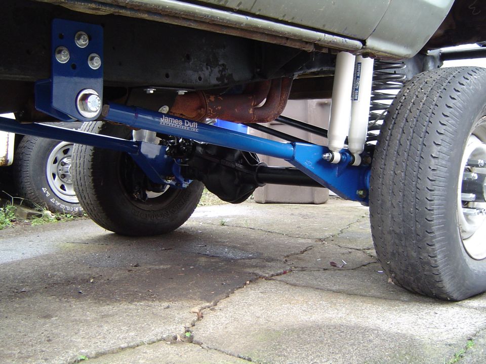 Blue suspension components and differential on a vehicle's underside, with a tire visible