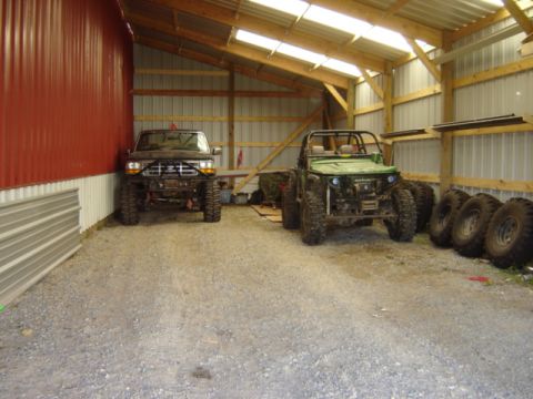 1992 Ford Bronco - Two modified off-road vehicles, a 1992 Ford Bronco and a buggy, are stored in a barn.
