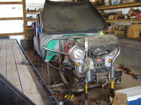 1992 Ford Bronco - This Jeep CJ-5 is undergoing some work in a cluttered garage, with its hood open and a winch mounted on the front.
