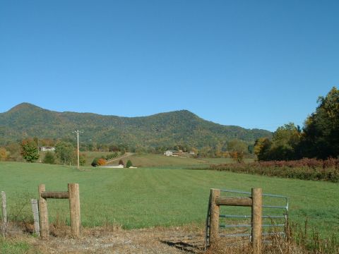1995 Ford Bronco - A scenic view of rolling hills and farmland, with a wooden fence and gate in the foreground.