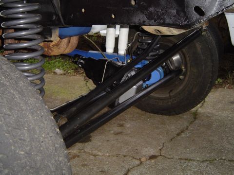 1978 Ford Bronco - Close-up view of a vehicle's modified suspension system, prominent blue-painted components and heavy-duty springs.