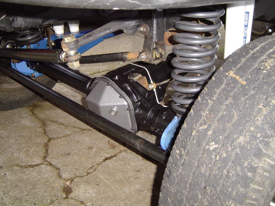Close-up of front axle, differential cover, and coil spring