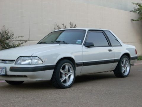 1991 Ford Mustang - White 1991 Ford Mustang coupe parked outdoors with a light-colored wall in the background.