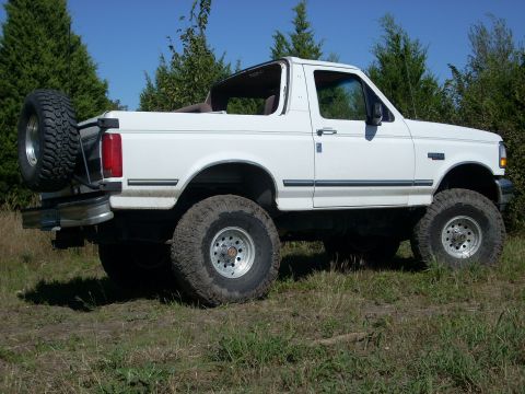 1992 Ford Bronco - White 1992 Ford Bronco with removable top, lifted suspension, and spare tire on rear.