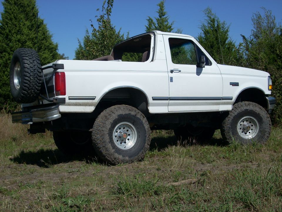 White 1992 Ford Bronco with removable top, lifted suspension, and spare tire on rear