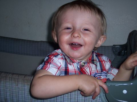 1972 Ford Ranchero - A happy toddler wearing a red, white, and blue plaid shirt smiles broadly while sitting in a crib.