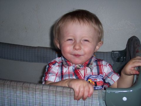 1972 Ford Ranchero - A young child smiles while sitting in a crib, wearing a plaid shirt with a Lightning McQueen graphic.