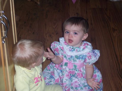 1972 Ford Ranchero - Two young children interact on a wooden floor, one wearing a floral dress and the other a yellow outfit.