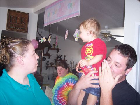 1972 Ford Ranchero - A group of people are gathered indoors, with a child being held up and a decorative banner hanging above.