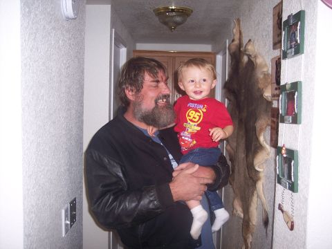 1972 Ford Ranchero - A man holds a smiling toddler wearing a red shirt with a 'Piston 95' graphic, standing in a hallway.