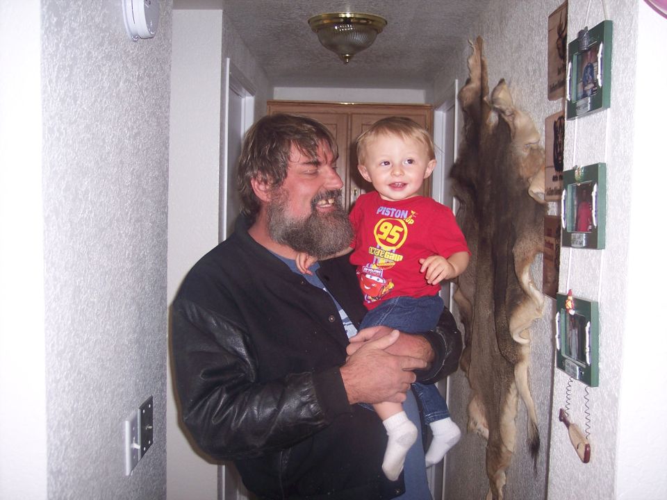 Man holding toddler wearing a red shirt with 'Piston 95' graphic
