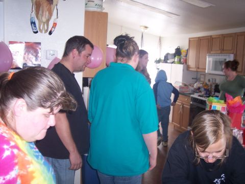 1972 Ford Ranchero - A group of people are standing around in a kitchen, possibly at a party or gathering.