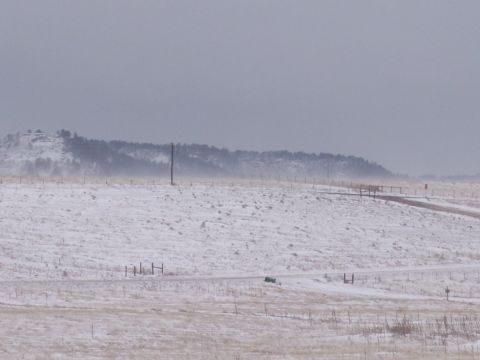 1972 Ford Ranchero - A green car is visible on a dirt road in a snowy landscape.