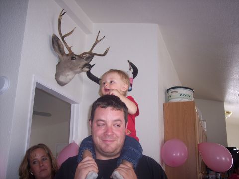1972 Ford Ranchero - A child sits on a man's shoulders, with a mounted deer head on the wall behind them.