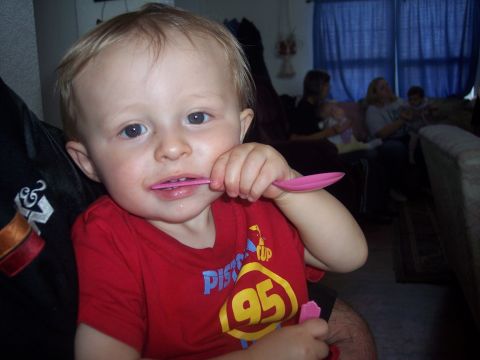 1972 Ford Ranchero - A young child plays with a pink spoon while sitting indoors with family in the background.