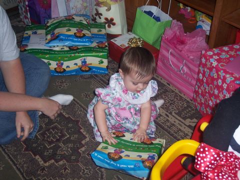 1972 Ford Ranchero - A baby sits on a rug, surrounded by colorful gifts and gift bags, as she begins to open a present.