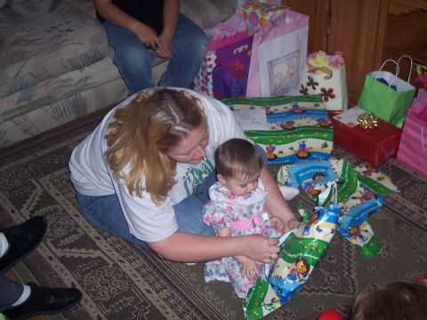 1972 Ford Ranchero - A woman helps a baby unwrap a gift, with several other presents and gift bags visible in the background.