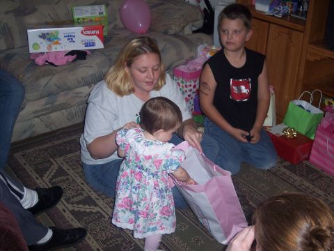 1972 Ford Ranchero - A woman and two children are gathered on the floor, opening gifts at what appears to be a birthday celebration.
