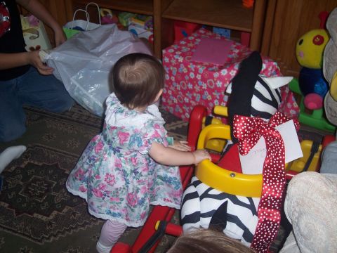 1972 Ford Ranchero - A child interacts with a toy zebra, surrounded by gifts and toys in a room.