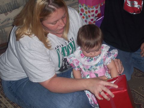 1972 Ford Ranchero - A woman and a baby are focused on opening a red gift box together.