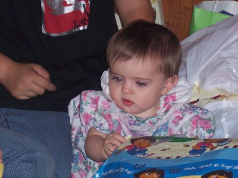 1972 Ford Ranchero - A baby in a floral dress looks to the side while sitting near a person.