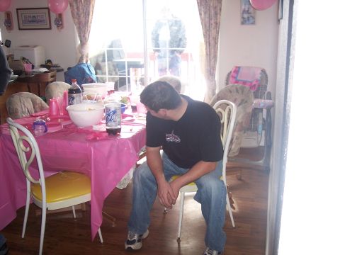 1972 Ford Ranchero - A man sits at a table set for a party, with pink decorations and drinks on display.
