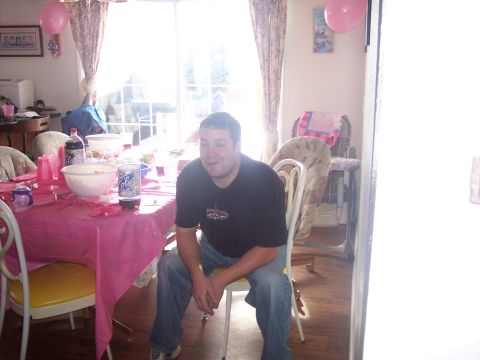 1972 Ford Ranchero - A man sits at a table set for a party with pink decorations and drinks.