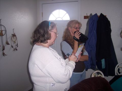 1972 Ford Ranchero - Two women are in a hallway, one is recording with a camcorder while the other reviews a document.