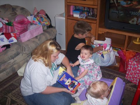 1972 Ford Ranchero - A family gathers on the floor to open presents, with a woman reading a book to the children.