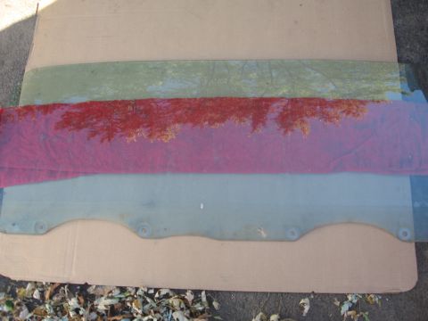 1979 Ford Bronco - Multiple glass panels are laid out on a cardboard surface, possibly for a vehicle.