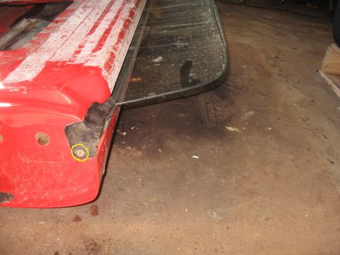 1979 Ford Bronco - Close-up of a red vehicle panel section with black rubber trim and a screw, showing part of a larger component.