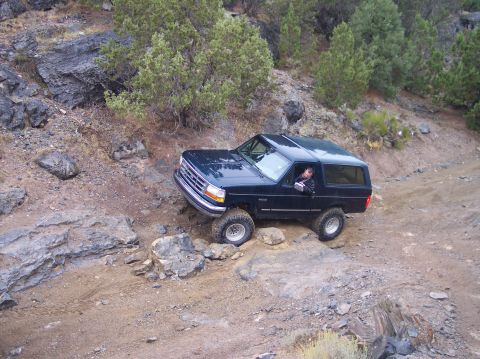 1995 Ford Bronco - This 1995 Ford Bronco is tackling a challenging off-road trail with steep inclines and large rocks.
