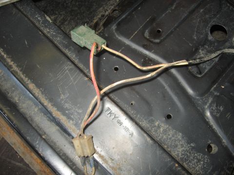 1979 Ford Bronco - Close-up of a wiring harness connector and wires on a metal surface.