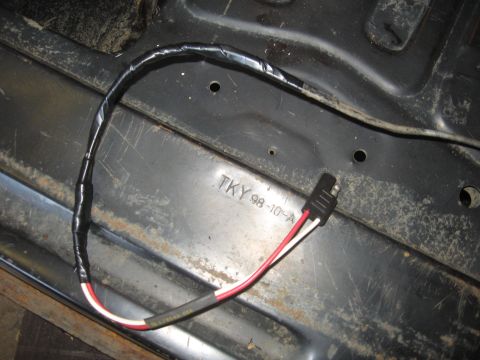 1979 Ford Bronco - A close-up view of a wiring harness and a metal surface with stamped markings.