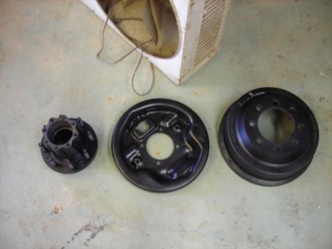 1995 Ford F-250 - Three automotive brake parts are laid out on a concrete surface.