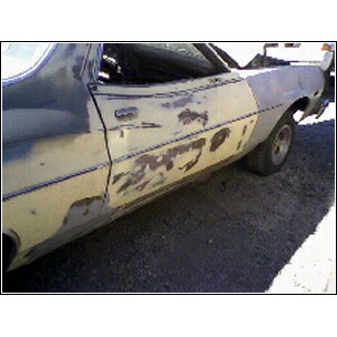 1972 Ford Ranchero - 1972 Ford Ranchero side panel undergoing repair with primer and body filler visible.