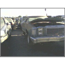 1972 Ford Ranchero - A 1972 Ford Ranchero sits in a junkyard with its hood open, showing the engine bay.