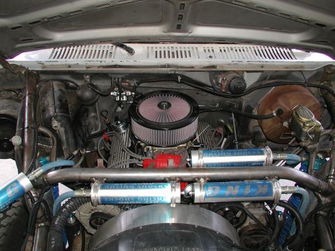 1980 Ford Bronco - The engine bay shows extensive modifications with prominent racing shocks and aftermarket air intake system.