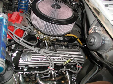 1980 Ford Bronco - Close-up of an engine bay prominent 'POWERED BY FORD' valve covers and an aftermarket air intake system.