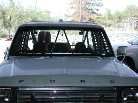 1980 Ford Bronco - Front view of a 1980 Ford Bronco's interior, modified with a roll cage and racing seats.