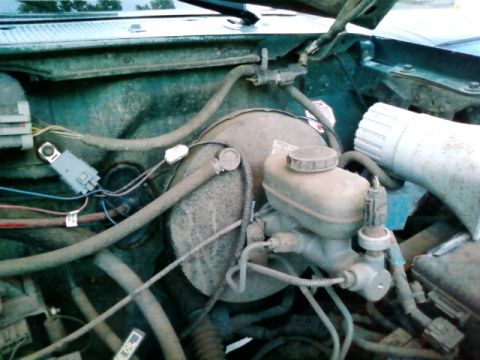 1995 Ford Bronco - Close-up view of a vehicle's brake booster and master cylinder components.