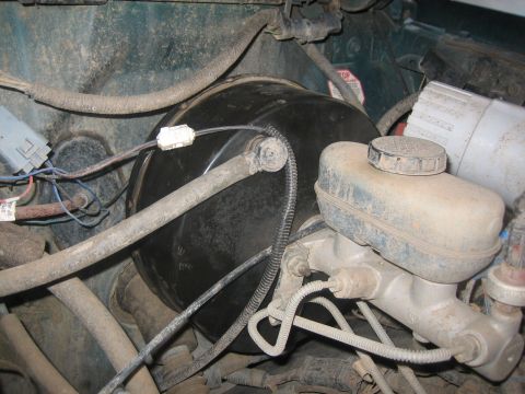 1995 Ford Bronco - The brake booster and master cylinder assembly are visible, along with associated hoses and wiring.