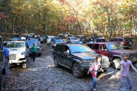 1992 Jeep Cherokee - A group of Jeeps and people gather in a wooded area during the autumn season.