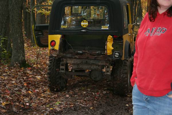 Yellow Jeep Wrangler rear view, damaged bumper, soft top