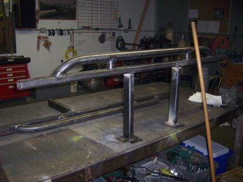 1991 Ford Bronco - Custom metal sliders fabricated in a workshop setting, resting on a workbench.