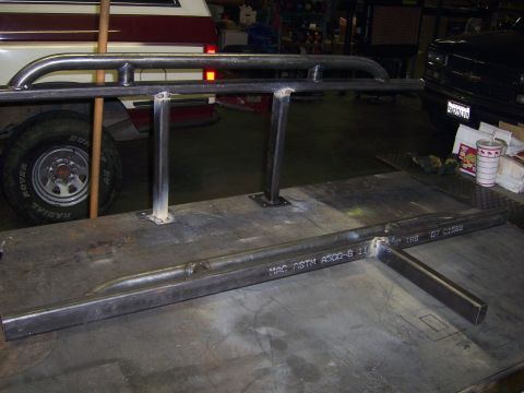 1991 Ford Bronco - Custom metal sliders are shown in a workshop setting, with parts of two vehicles visible in the background.